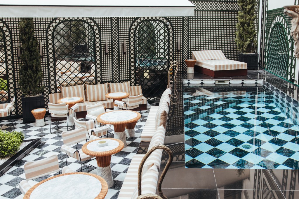 Sax Paris, LXR Hotels & Resorts - The Garden Pool, pool with chess board style bottom, surrounded by orange and white striped tables and chairs