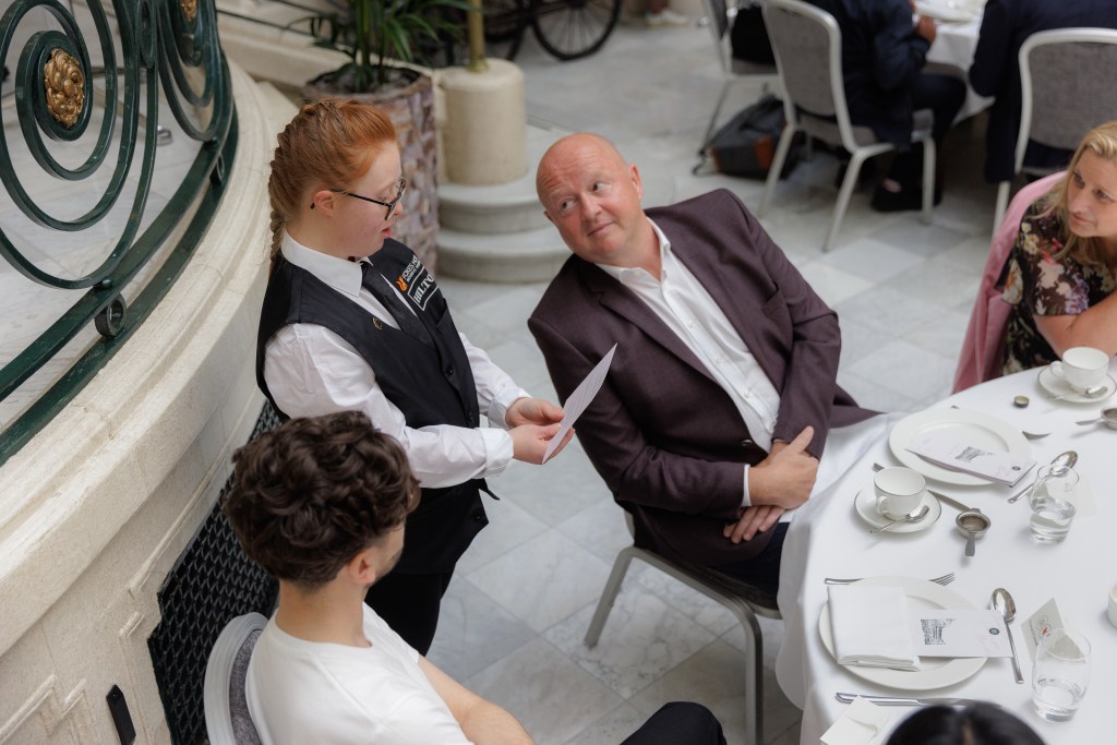 Hilton A Meal to Change Minds Event with Aurora Foxes Student Serving Guest