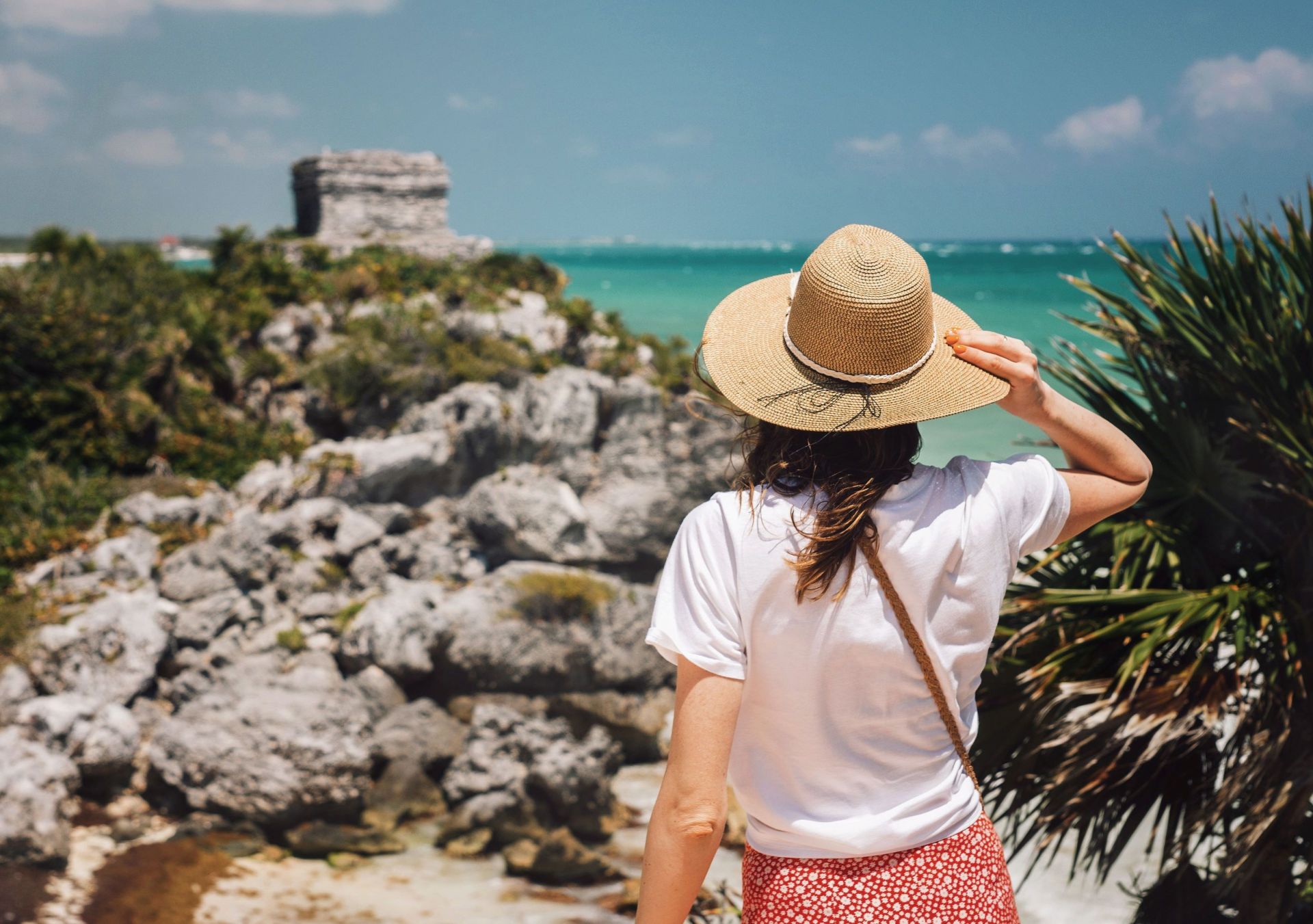 Conrad Tulum Riviera Maya - Tulum Ruins - woman wearing a hat overlooking ruins in Tulum, Mexico