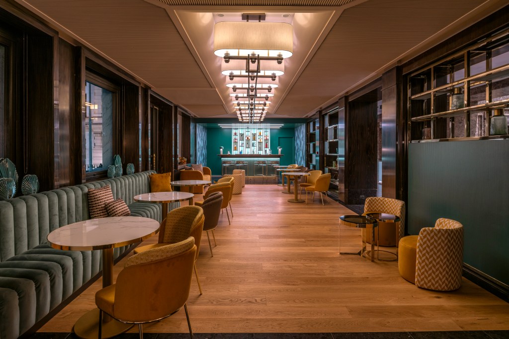 Hilton Turin Centre Alchemy the Bar, booth, tables, chairs and bar area in the background with high back chairs