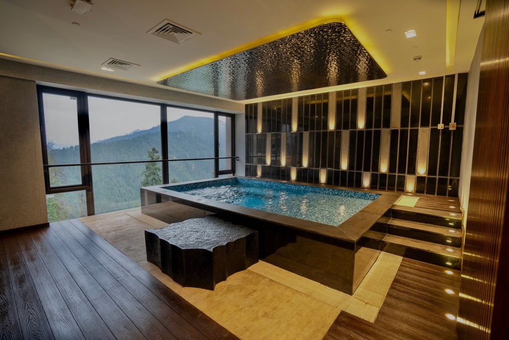 DoubleTree by Hilton Nathiagali Pool indoor with pine forests view and dim lighting throughout the room