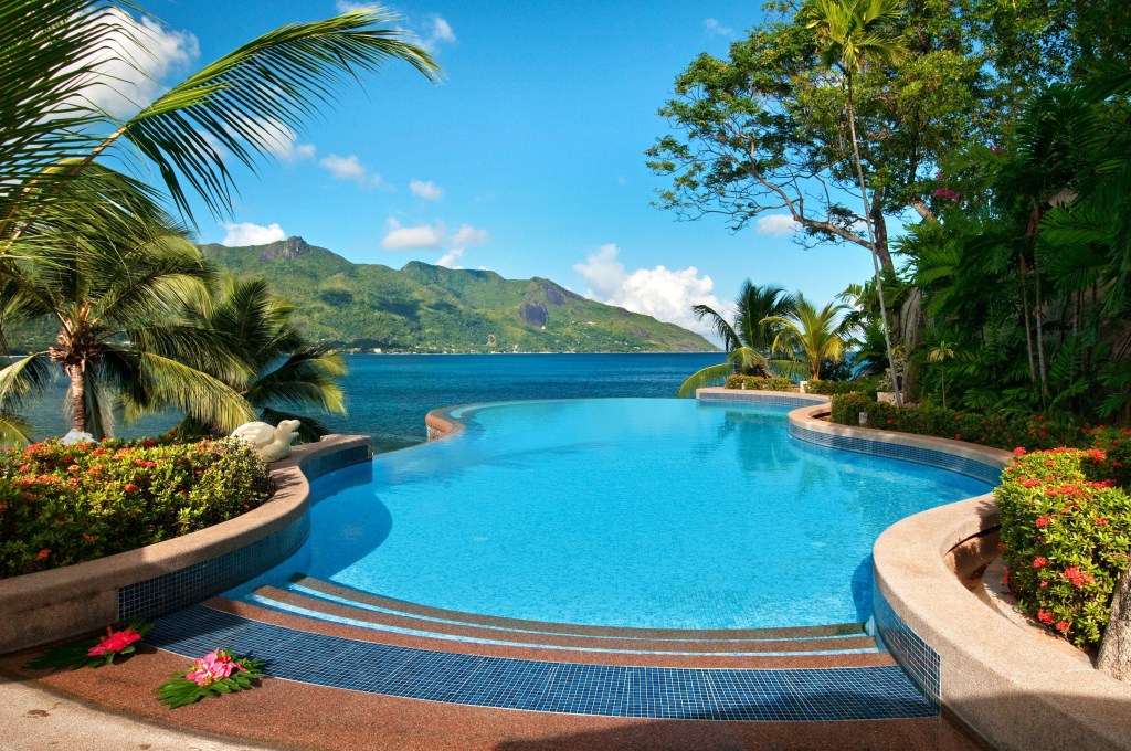 Hilton Seychelles Northolme Resort and Spa Pool, infinity pool with ocean view surrounded by flowers and green plants and palm trees