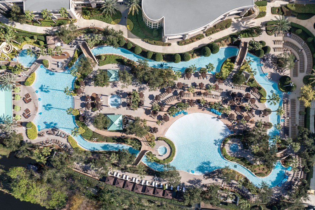 Signia by Hilton Orlando Bonnet Creek Pool Aerial, pools, brown umbrellas, green umbrellas, pool area landscaping