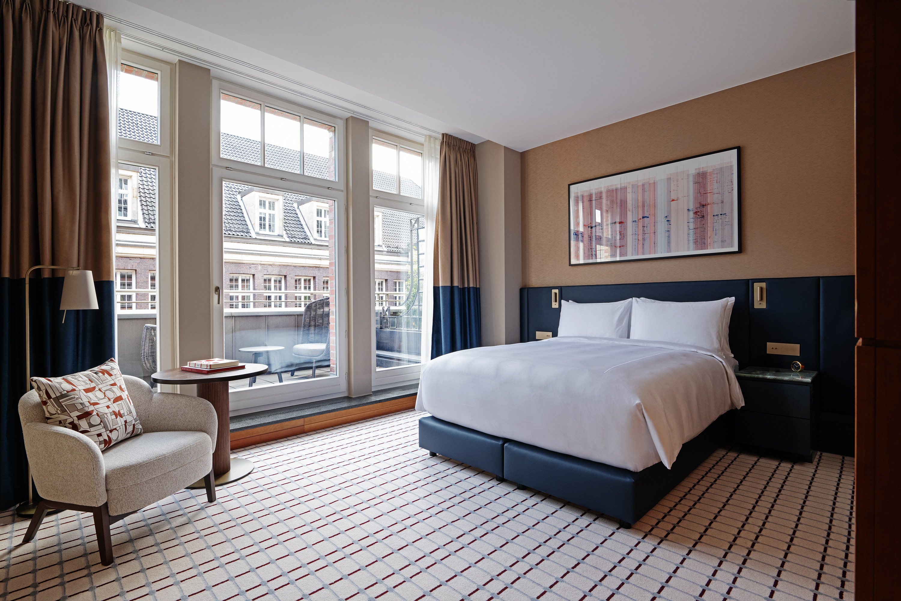 A bright bedroom with large windows looking out on a balcony