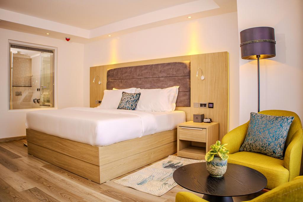 A room with bed, table and chairs, with accents of yellow and purple
