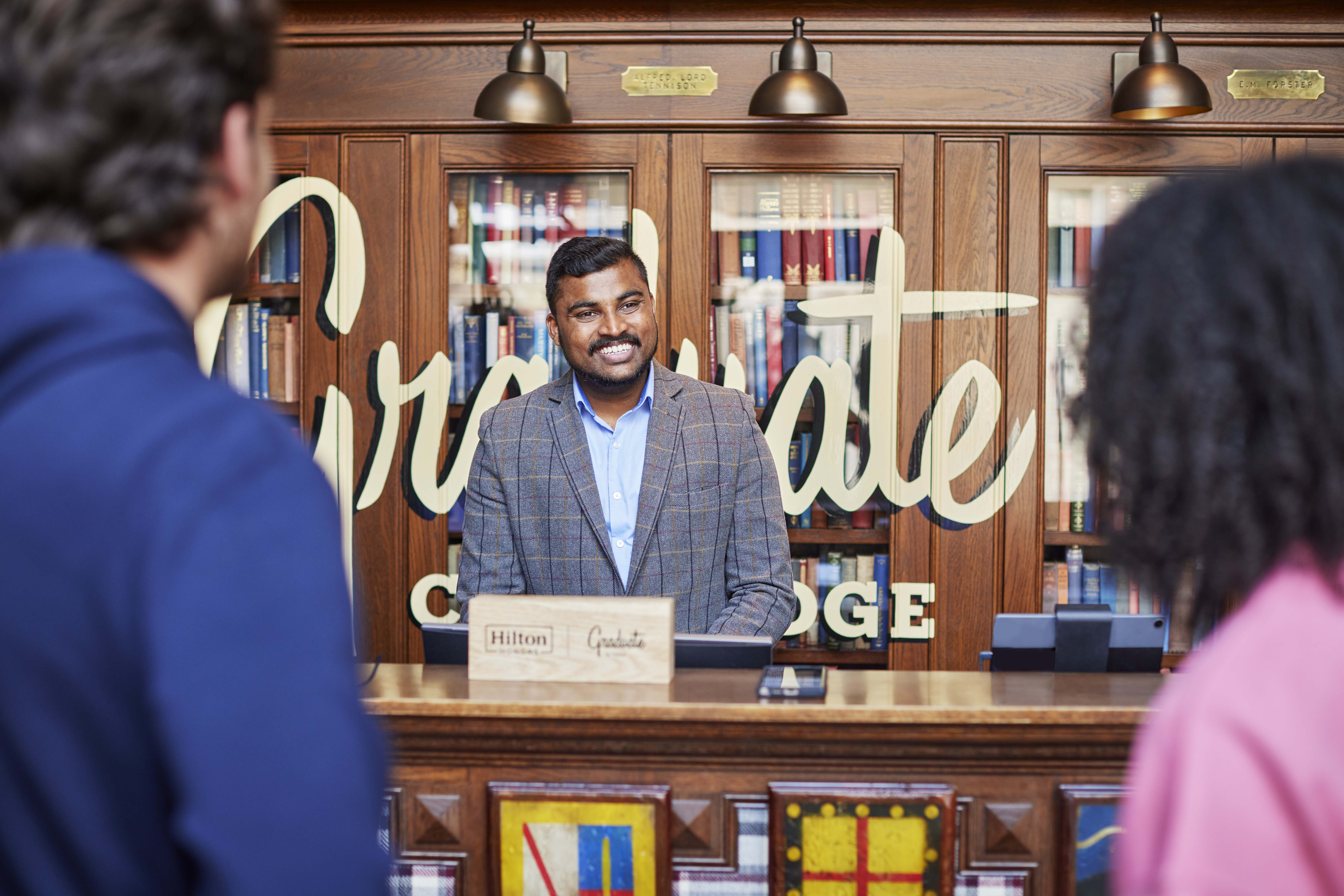 Graduate by Hilton Cambridge, team member greeting guests at front desk