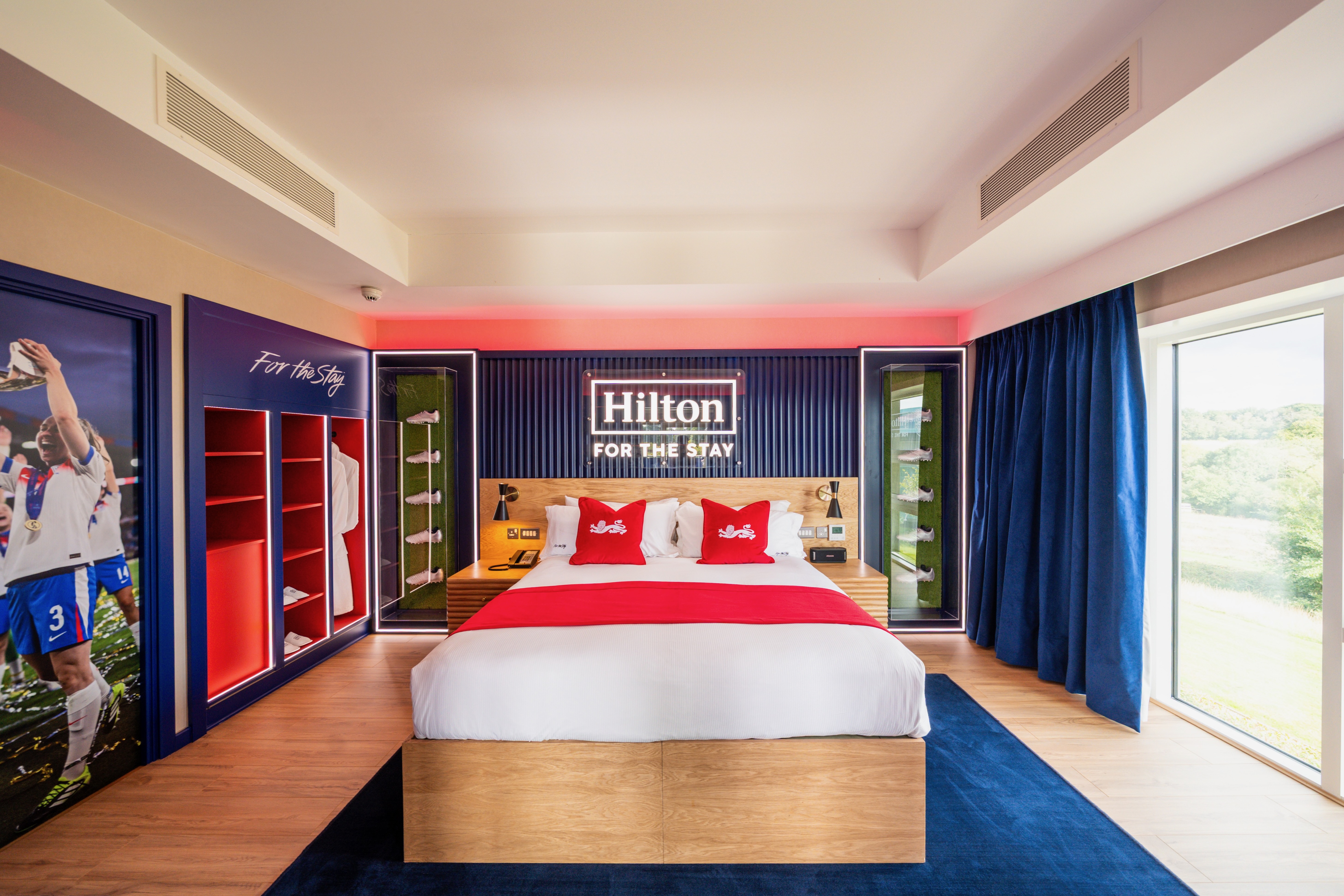 Facing the bed framed in memorabilia, with a wardrobe and large window