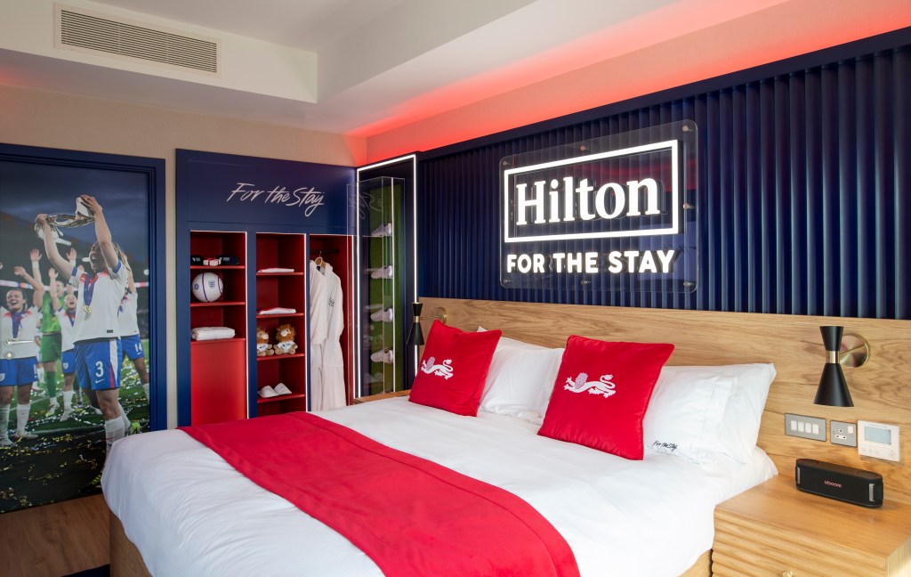 The bed framed in memorabilia, with the wardrobe in the background