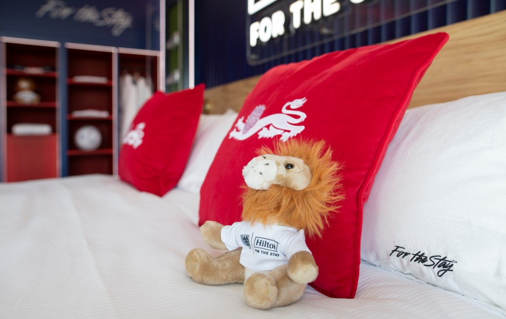 A close up of the bed and lion mascot stuffed animal.