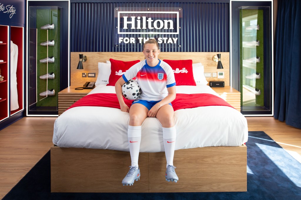 Ella Toone sitting on the bed holding a football