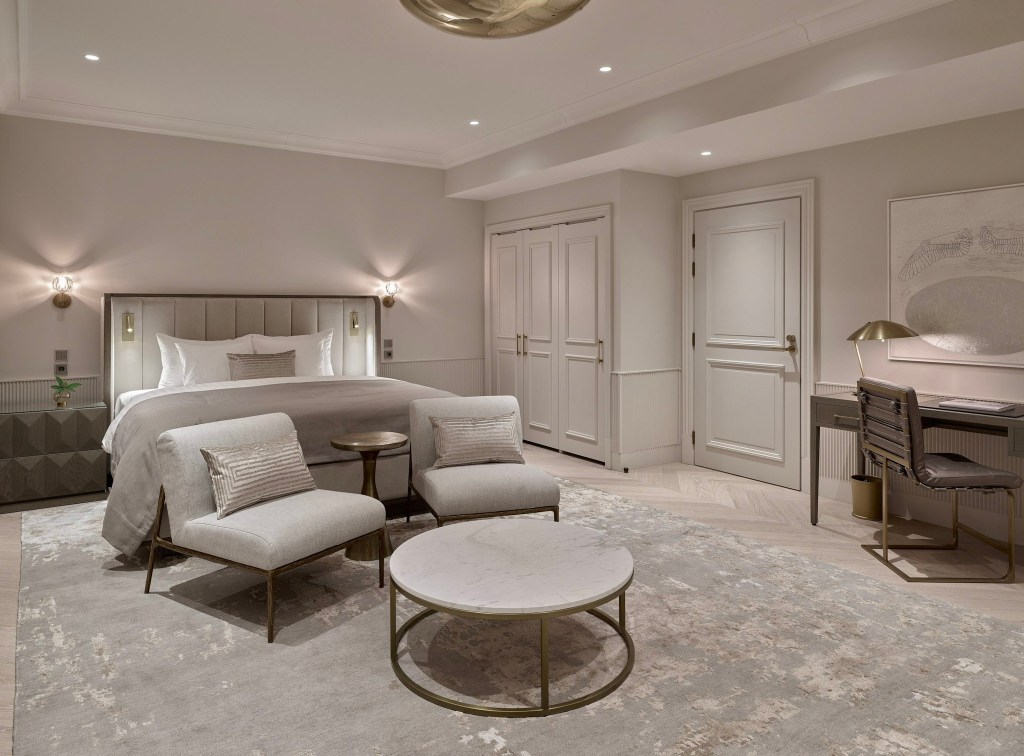 Spacious guest room with neutral tones and seating area.