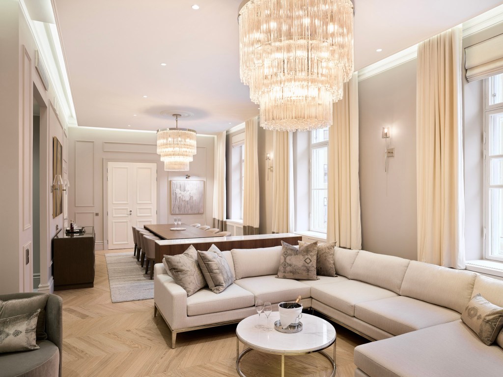 Luxurious suite with chandelier and spacious living area.