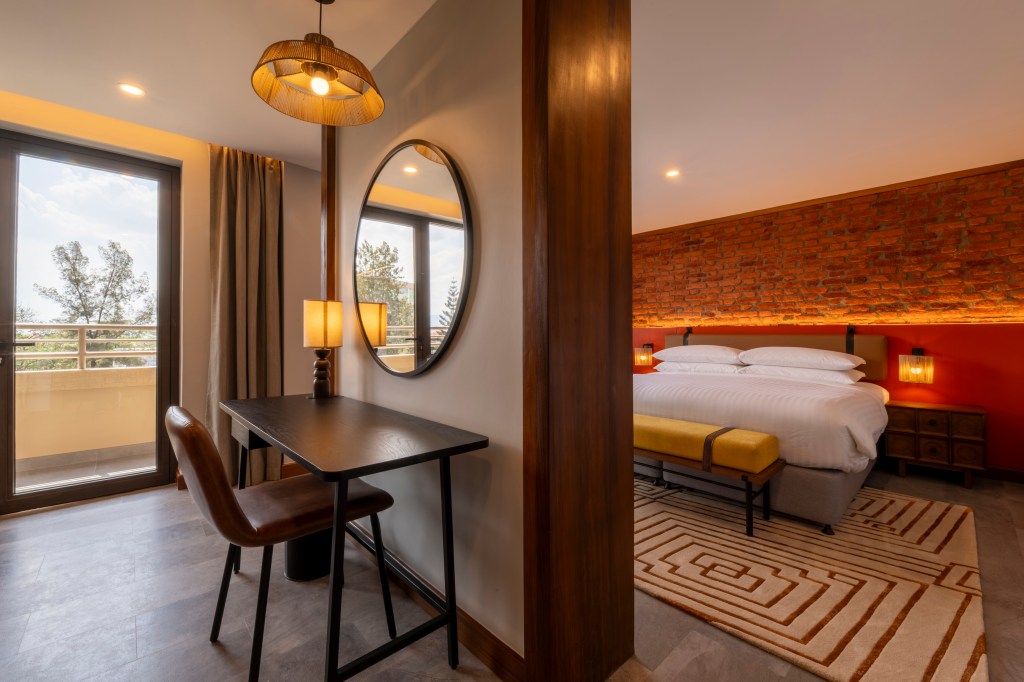 A room with bed, bench, a dividing wall, and desk
