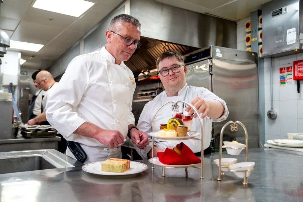 George placing desserts on a tray with another man