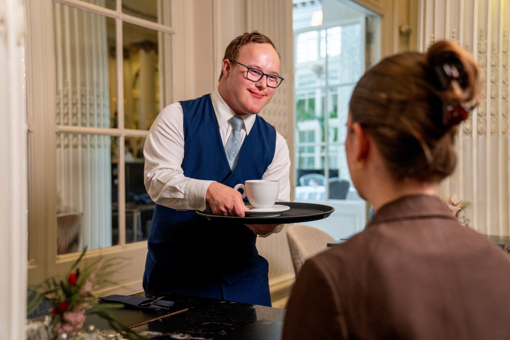 Sam serving a drink to a guest