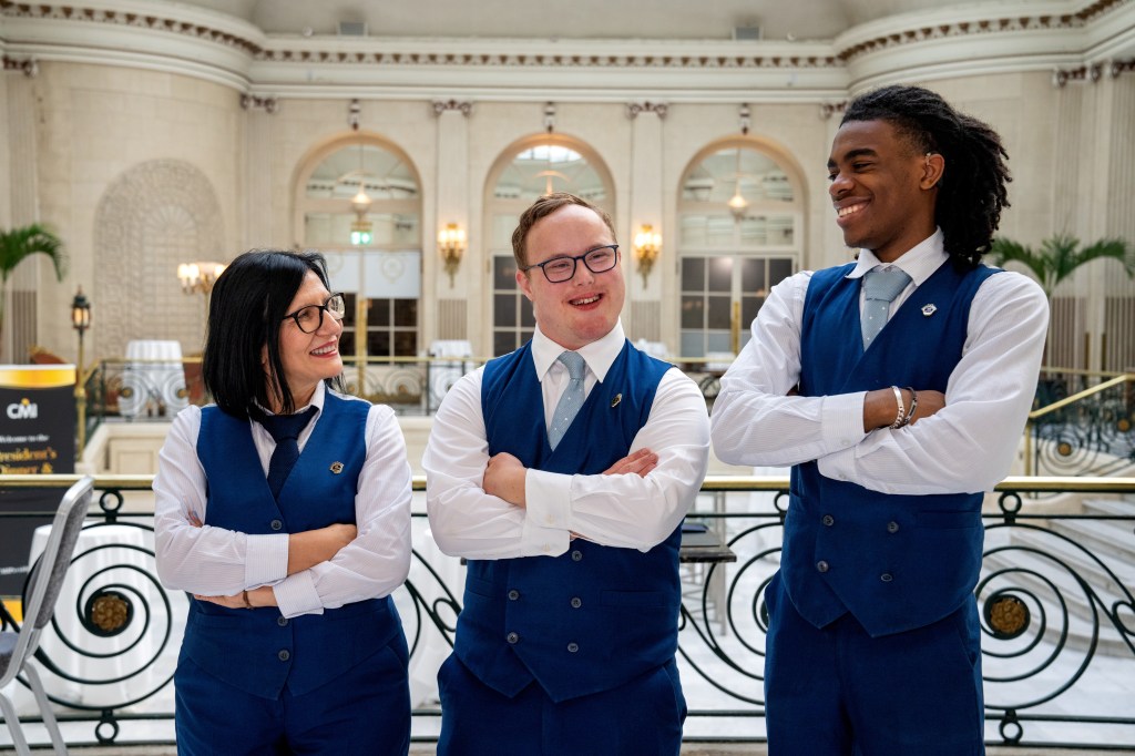 Sam with two other coworkers smiling at each other