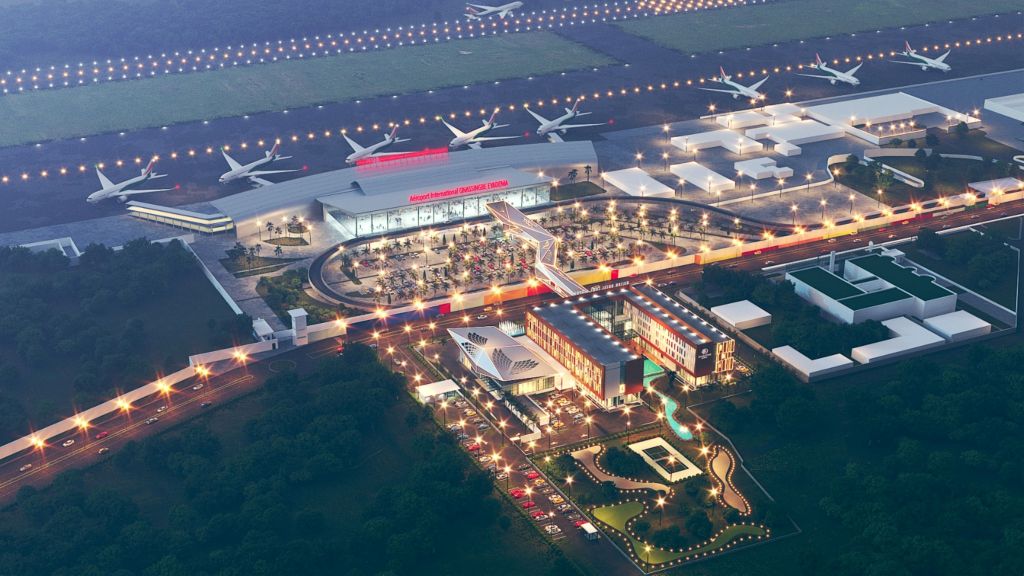 An aerial shot of the hotel at night, with bridge connecting to the airport