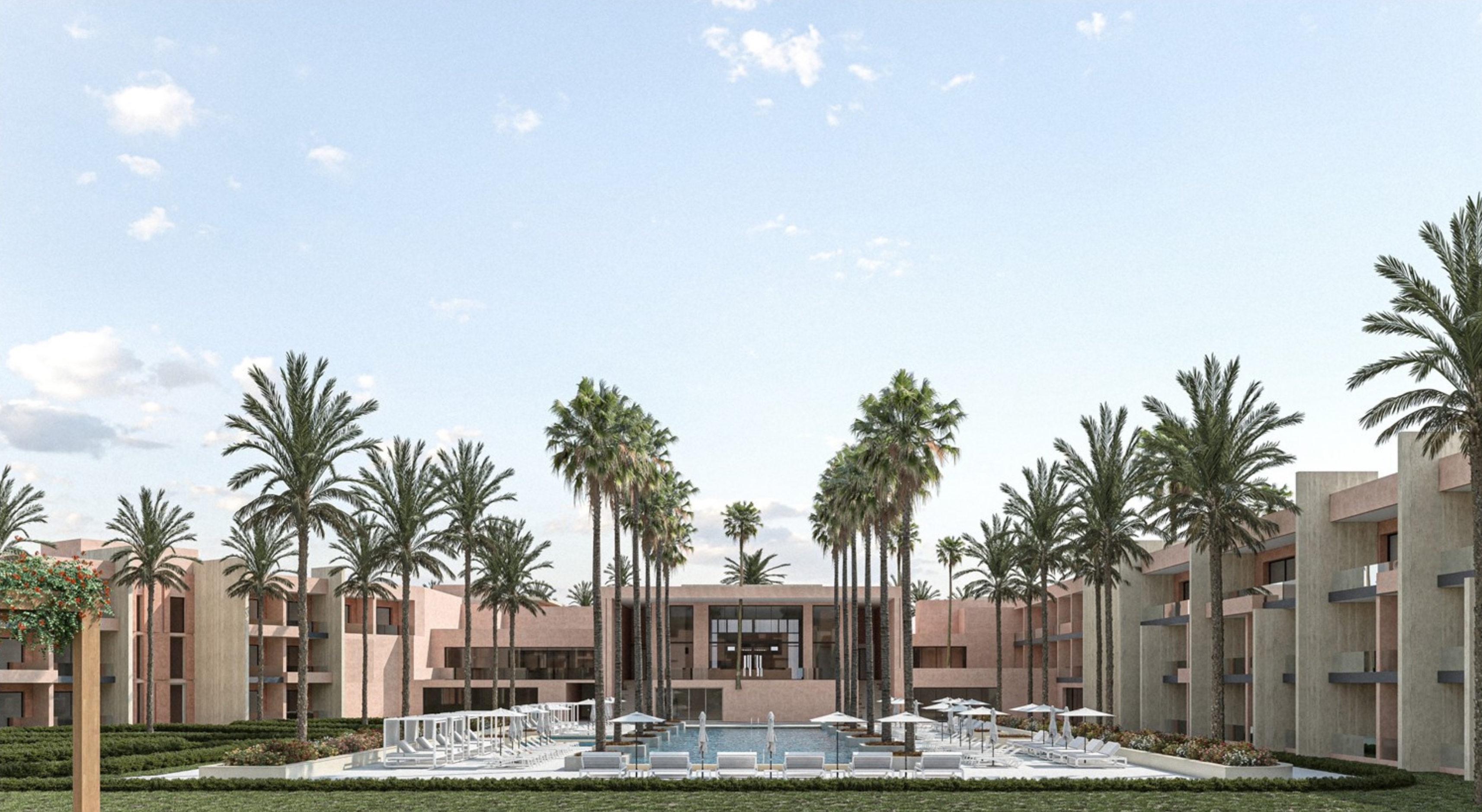 The pool surrounded by lounge chairs and umbrellas, with the hotel in the background