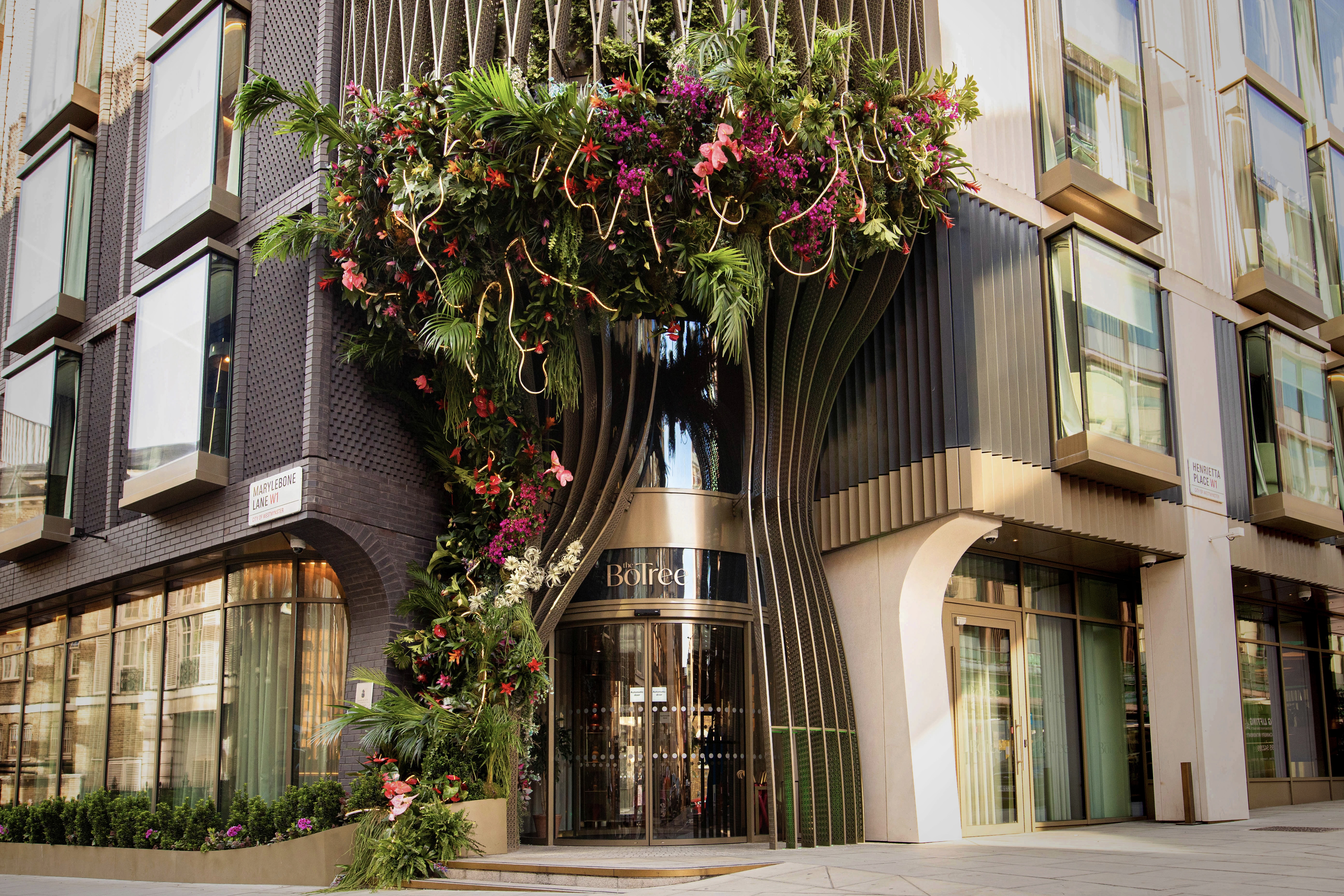 The exterior of the hotel with an elaborate greenery decoration around the front door