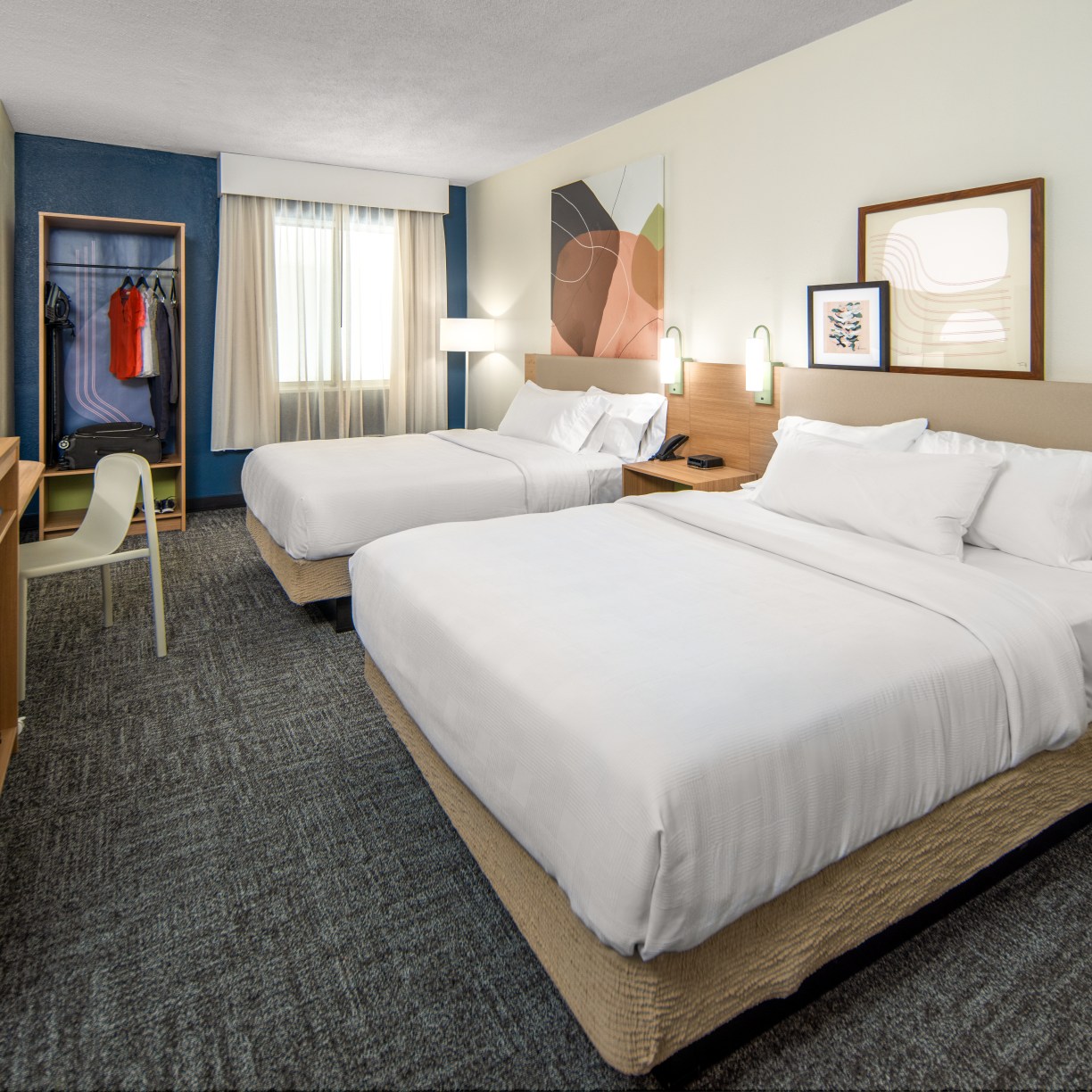 2 queen beds in guest room with closet and tv at Spark by Hilton a new hotel brand
