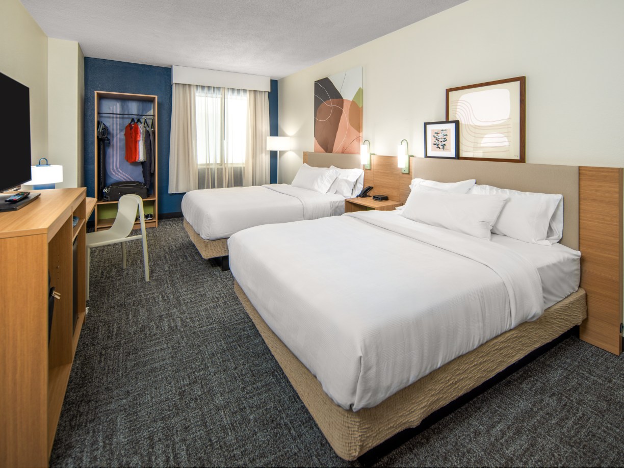 2 queen beds in guest room with closet and tv at Spark by Hilton a new hotel brand