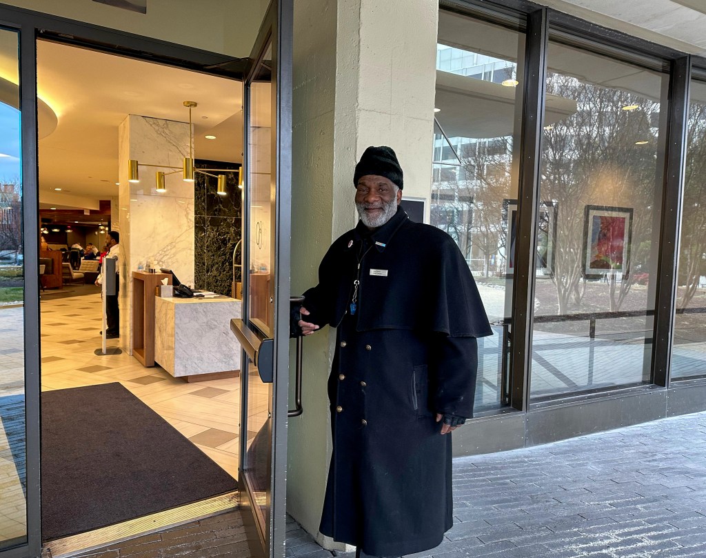 Guy Burton, doorman at Washington Hilton, opening door at hotel entrance