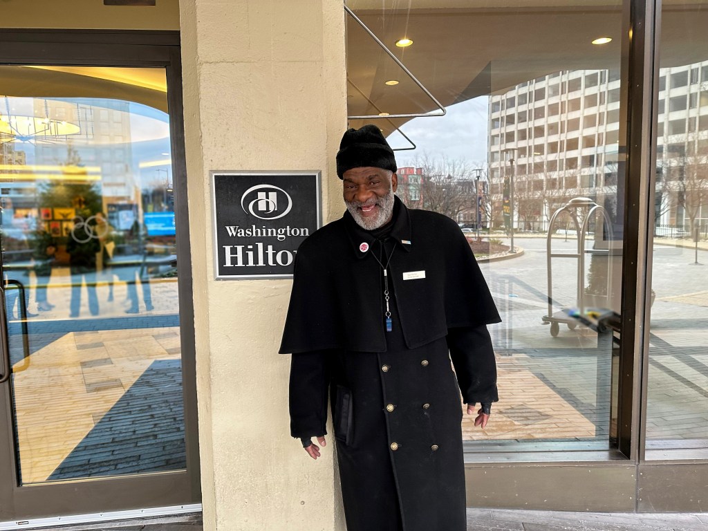 Guy Burton, doorman at Washington Hilton, smiling at hotel entrance