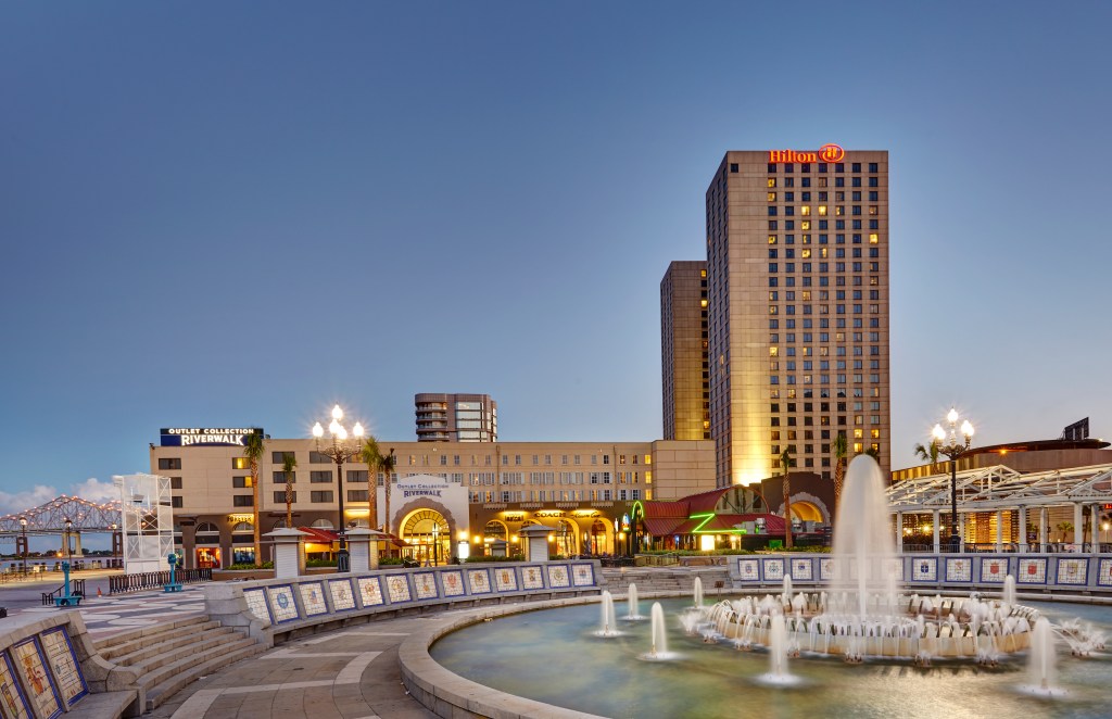 Hilton New Orleans Riverside - large water fountain in foreground with Hilton New Orleans Riverside and Riverwalk mall behind it