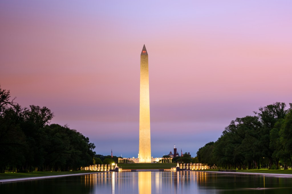 Washington Monument with brilliant sunrise over reflecting pool, Washington DC, USA