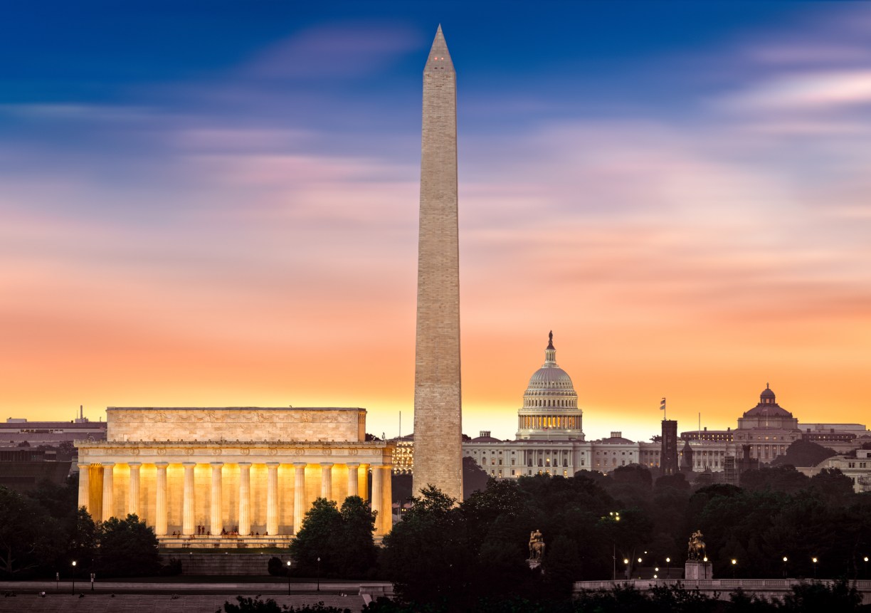 New dawn over Washington - with 3 iconic monuments illuminated at sunrise: Lincoln Memorial, Washington Monument and the Capitol Building.