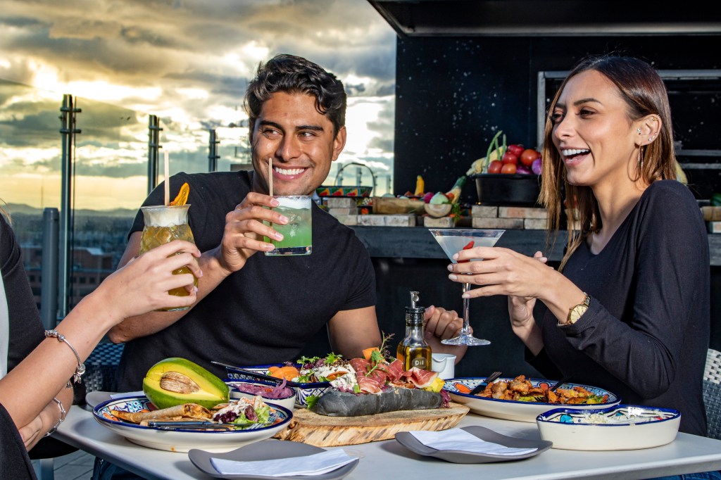 Guests with drinks at Sky 15 Rooftop at Hilton Bogota