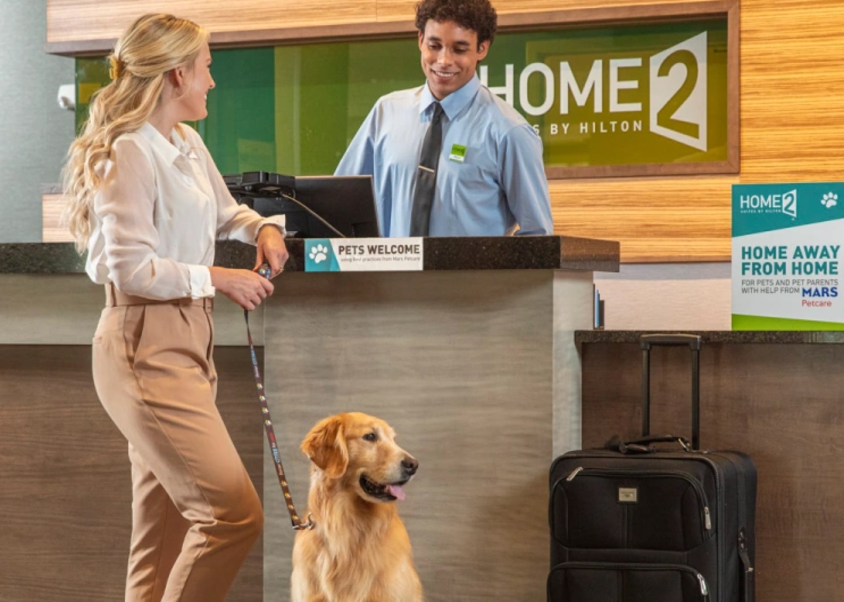 Woman checking in to a Hilton Hotel with a dog.