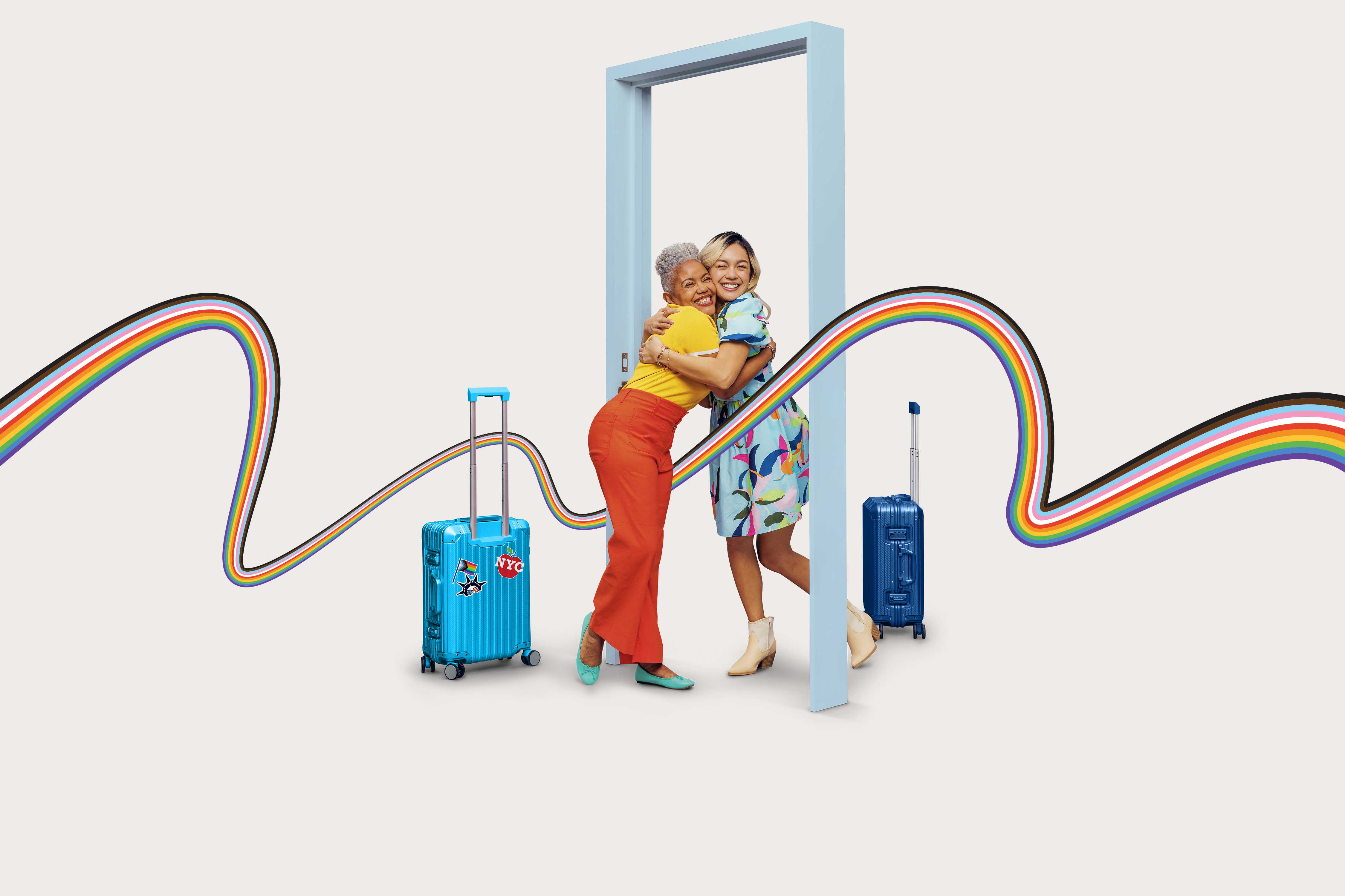 Women hugging with suitcases and rainbow