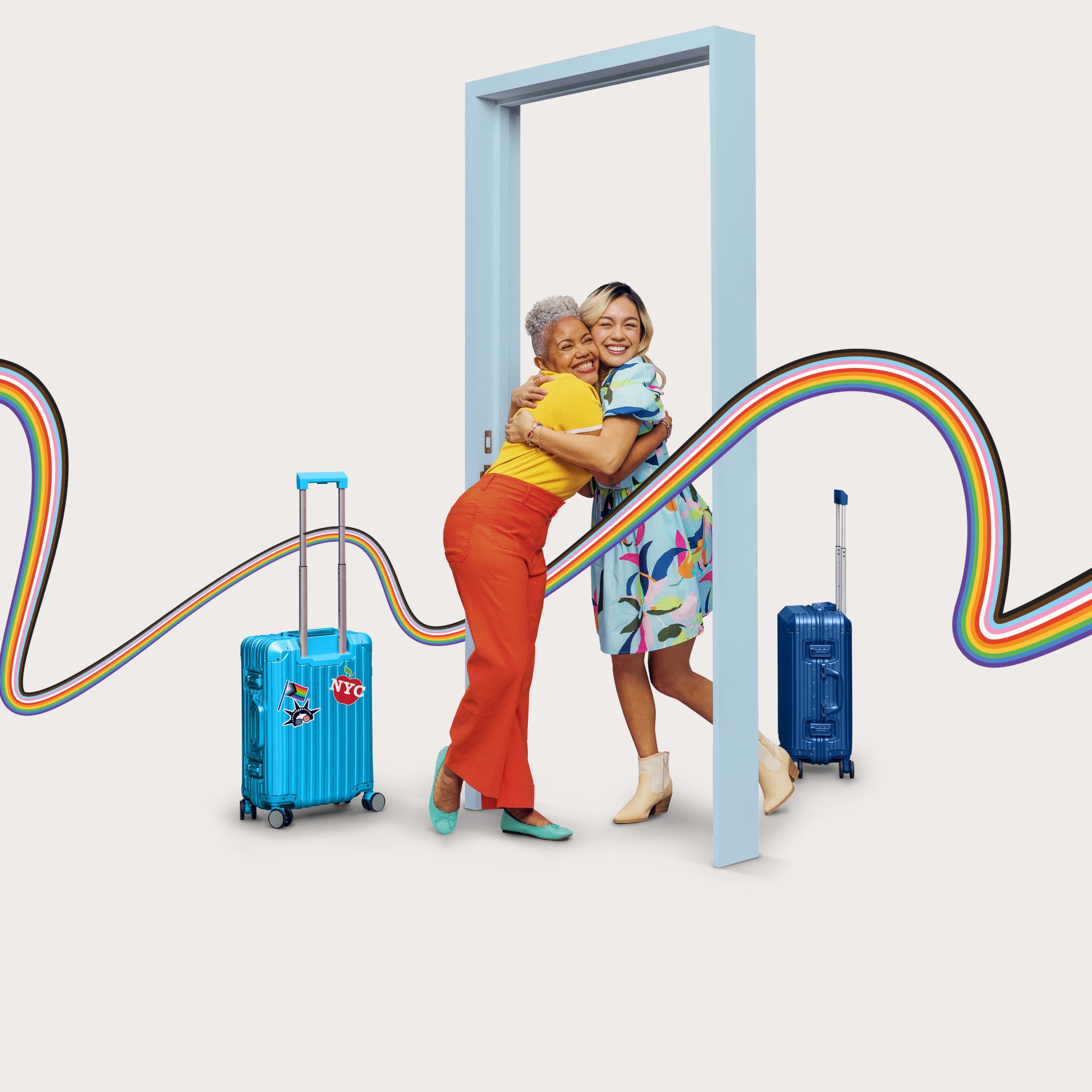 Women hugging with suitcases and rainbow