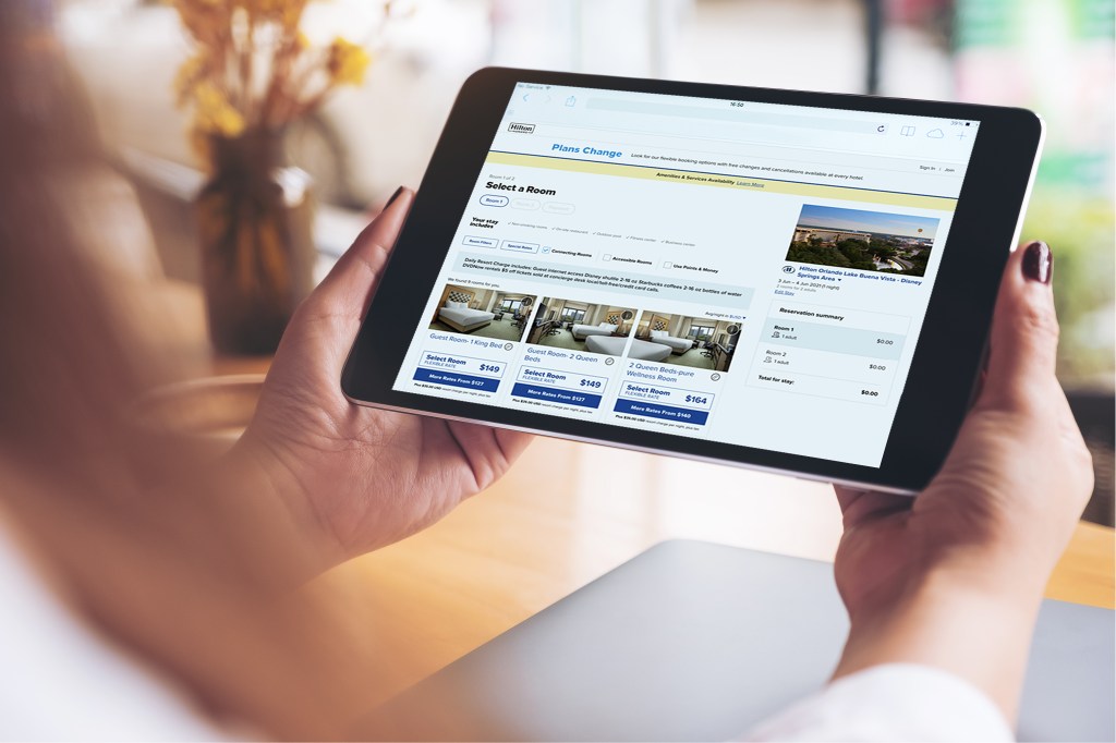 Person holding iPad with Hilton.com booking experience on the screen