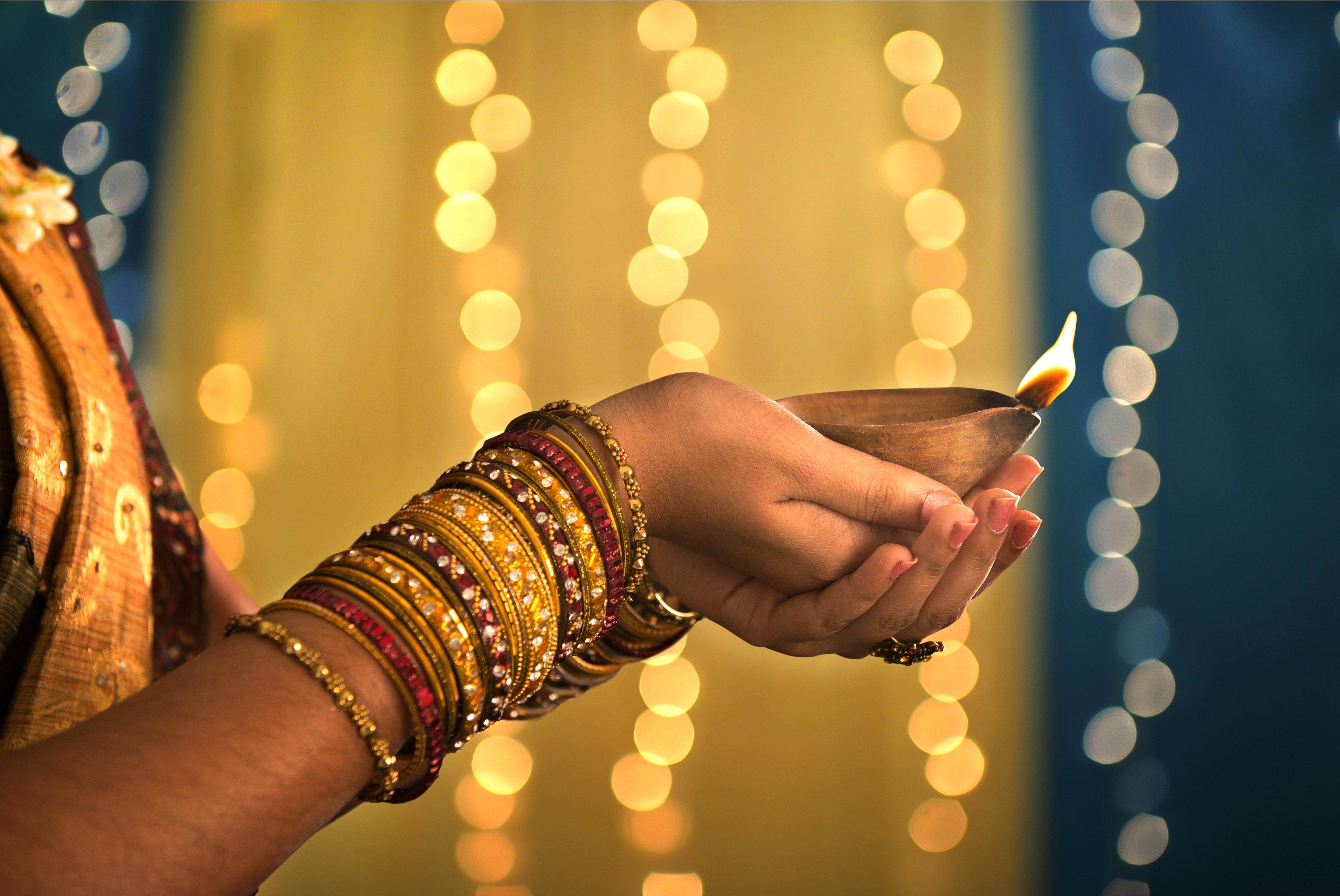 Diwali Festival of Lights, Hands holding oil lamp. Photo Credit: wong yu liang/Shutterstock