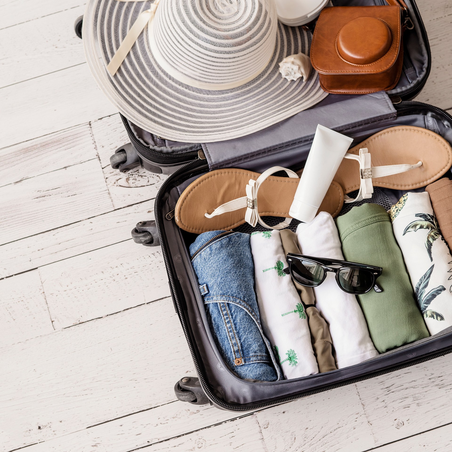 Luggage,And,Suitcase,Packing,For,Vacation,On,White,Wooden,Background