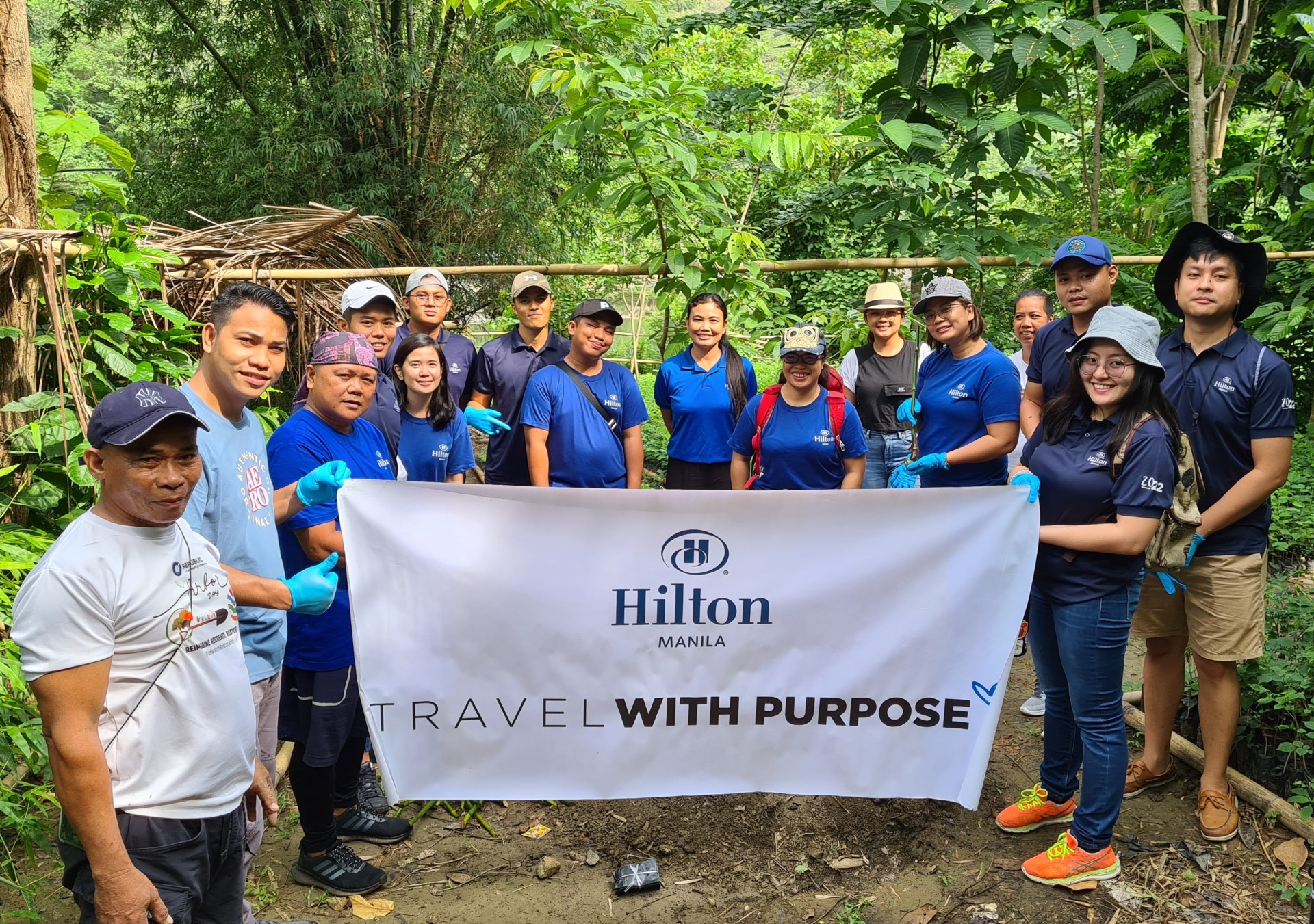 Hilton Manila team members holding Travel with Purpose banner