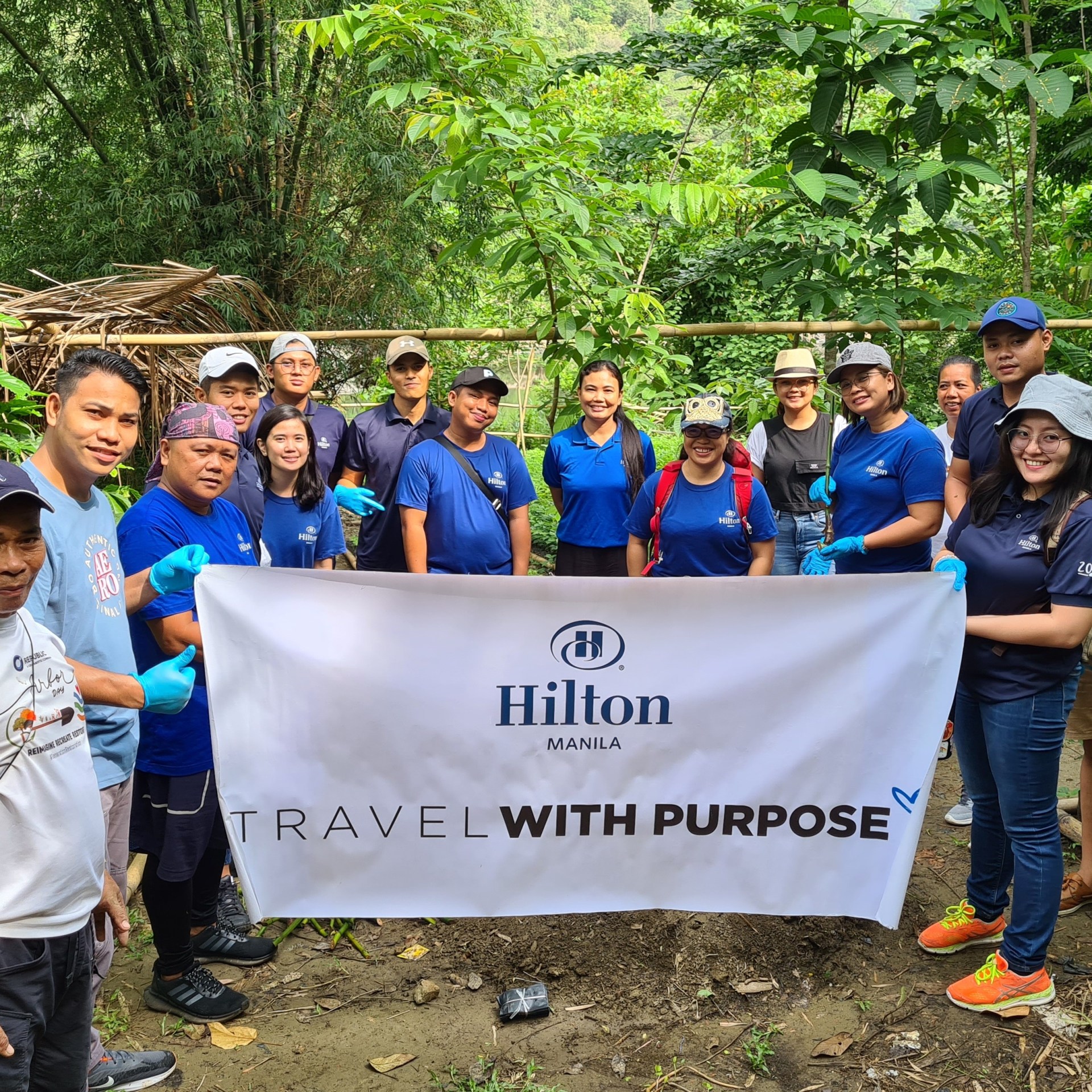 Hilton Manila team members holding Travel with Purpose banner