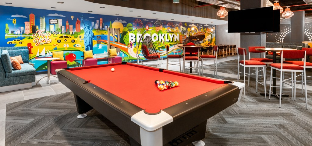 Tru by Hilton Brooklyn - Lobby featuring colorful mural, pool table and seating