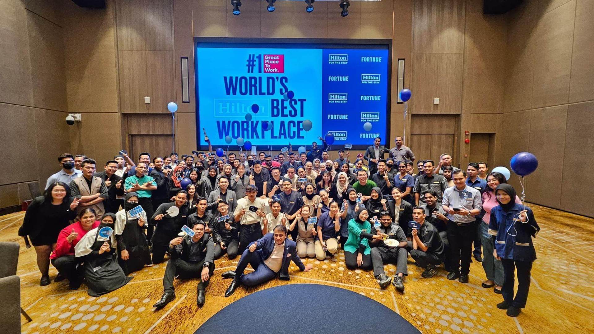 A group photo celebrating an award for #1 Worlds best workplace