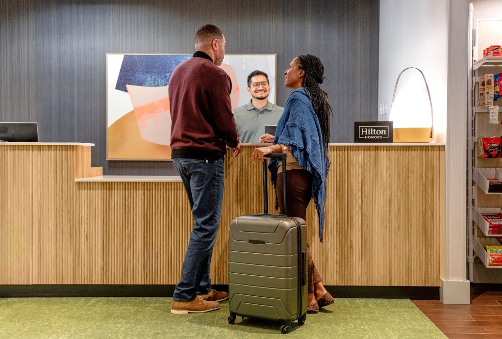 guests and team member at the Spark by Hilton check-in counter