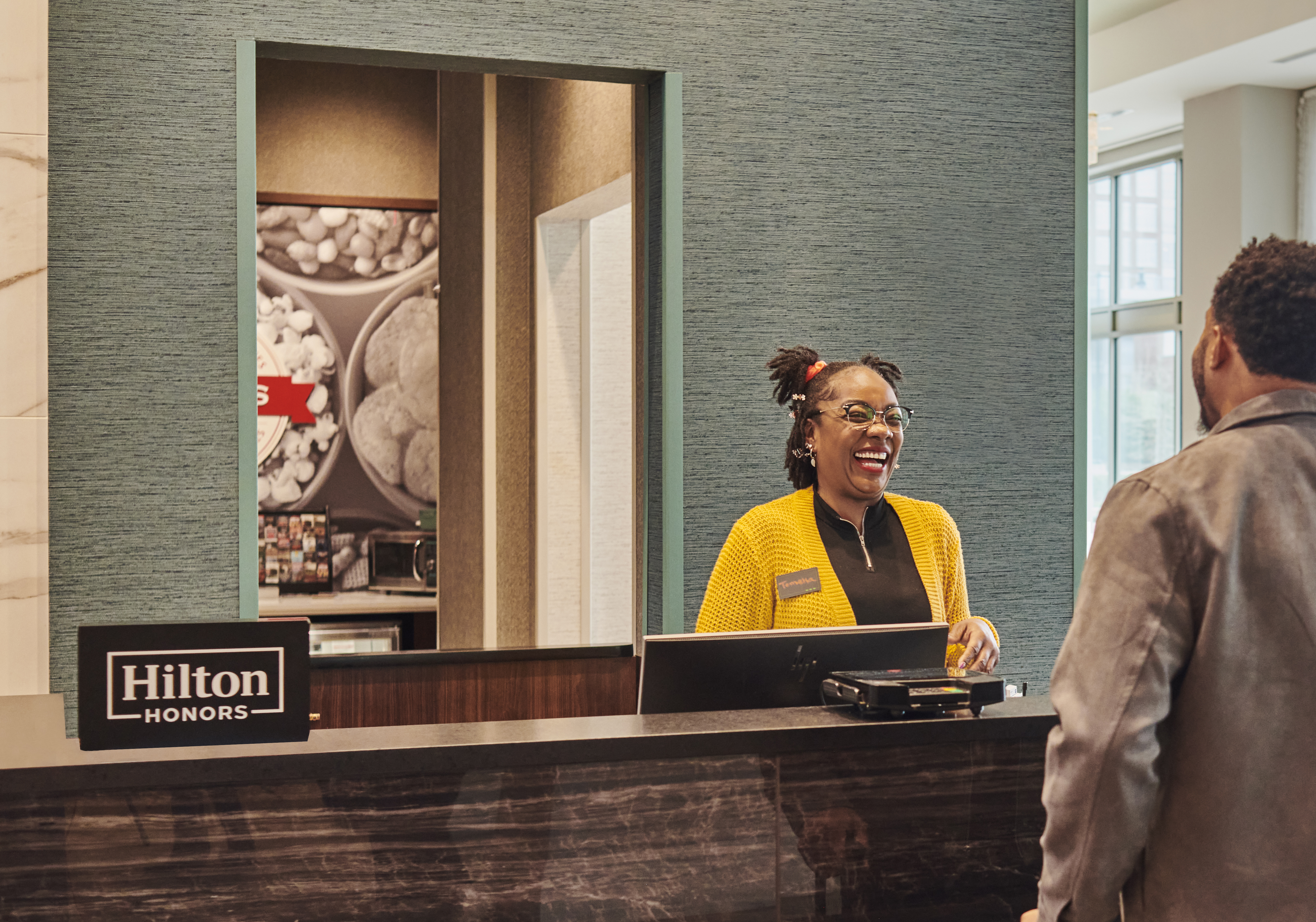 Team Member talking to guest at Front Desk - Hampton by Hilton