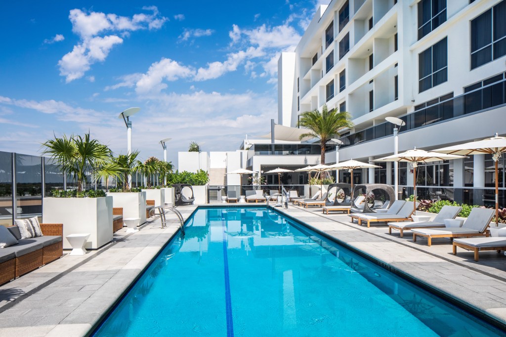 Hilton Miami Aventura - Pool, lounge chairs, outdoor couches, palm trees