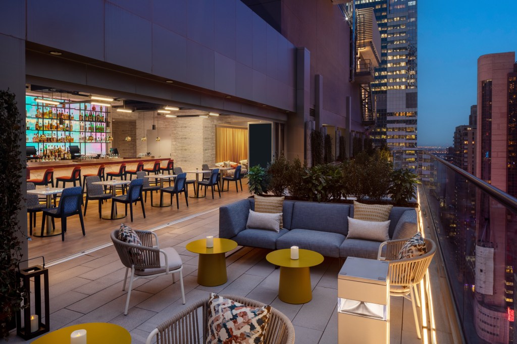 Hampton New York Times Square Interlude Rooftop Lounge bar and balcony seating areas, couch, pillows, chairs