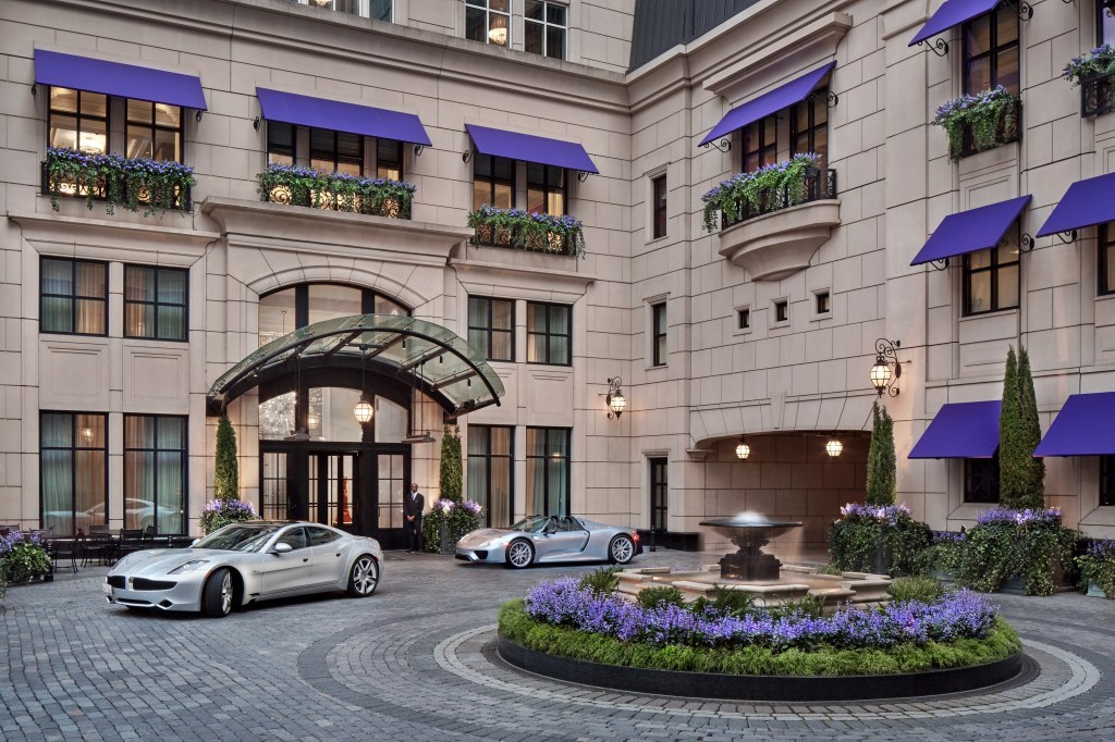 Waldorf Astoria Chicago - Courtyard, lavender flowers surrounding fountain in drive way, two silver luxury cars, lavender flowers on balconies, lavender awnings, doorman