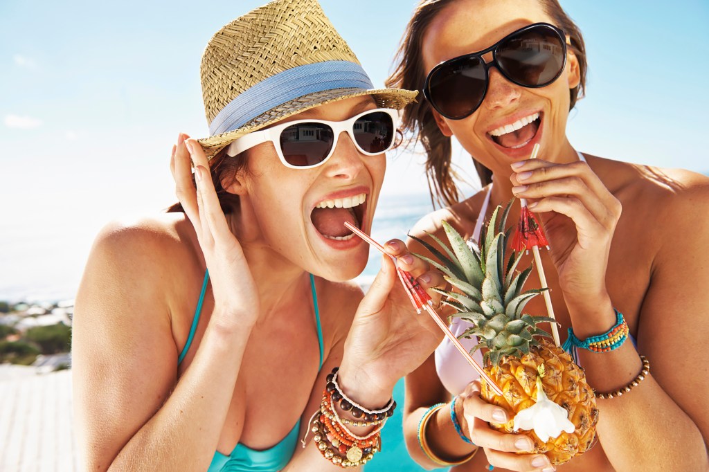 Women drinking Piña Colada in a pineapple cup