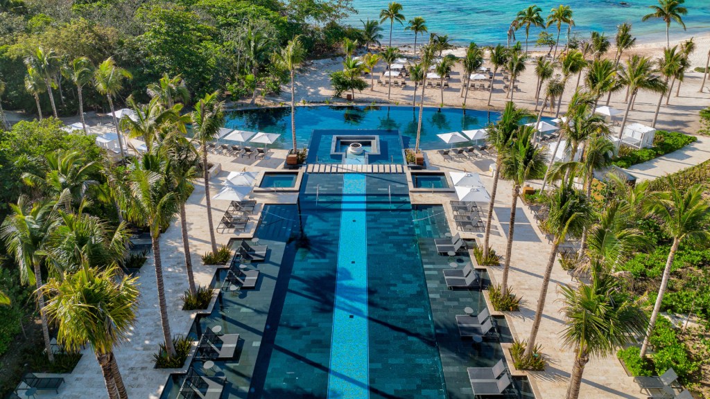 Conrad Tulum Riviera Maya - Pool, aerial view of palm trees, beach, ocean beach chairs, beach chairs with umbrellas