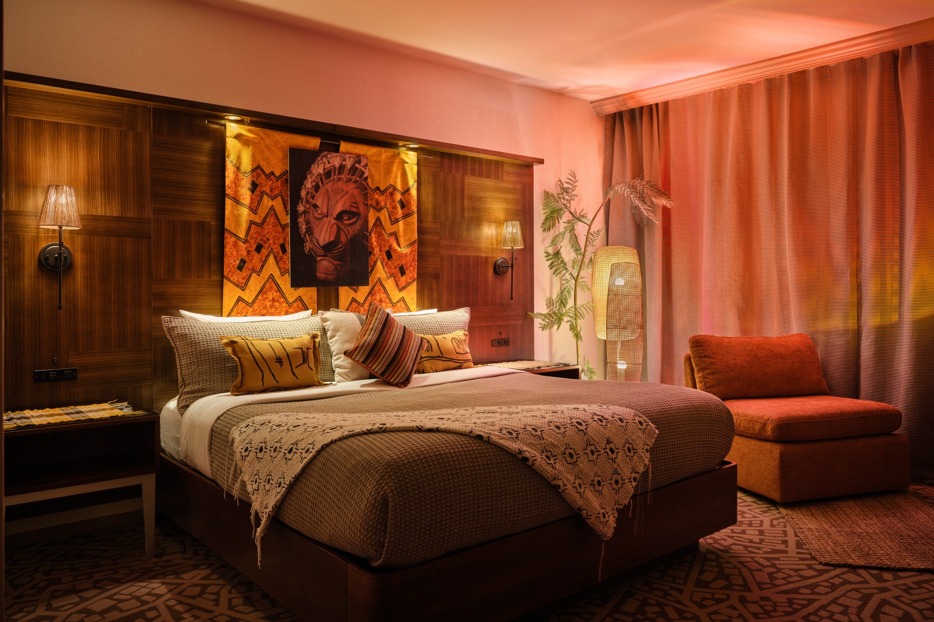 Hilton New York Times Square_THE LION KING's Royal Suite Bedroom, Broadway Lion King mask imagery, themed pillows, curtains, bedspread and chair, lamp and plant
