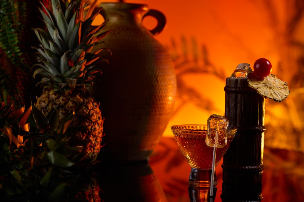 Hilton New York Times Square_THE LION KING's Royal Suite Cocktails with decorative fruit and ice stir, pineapple and vase in background